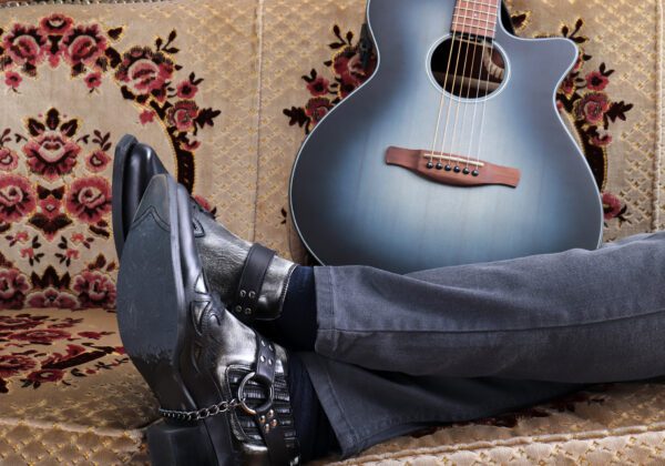 Cowboy boots and guitar. He is resting.